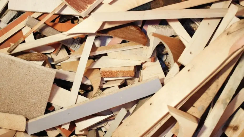 Imagem de resíduos de madeira, incluindo pedaços e restos de elementos em diversas formas e texturas, ideal para projetos de reciclagem e marcenaria.